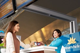 Nhân viên Vietnam Airlines phục vụ hành khách tại quầy làm thủ tục bay. (Ảnh: PV/Vietnam+)
