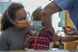 Tiêm vaccine phòng COVID-19 cho trẻ nhỏ tại Mỹ. (Ảnh: AFP/TTXVN)