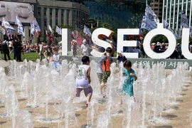 Trẻ em Hàn Quốc vui đùa tại đài phun nước tại Quảng trường trước Tòa thị chính Seoul dưới cái nắng gần 40 độ C. (Ảnh: Anh Nguyên/TTXVN)
