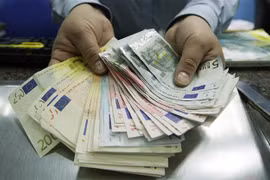 Nhân viên giao dịch ngoại hối kiểm đồng euro tại London, Anh. (Ảnh: AFP/TTXVN)