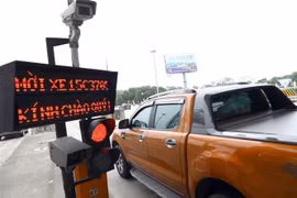 Xe cá nhân đi qua một trạm thu phí không dừng. (Ảnh: Huy Hùng/TTXVN)