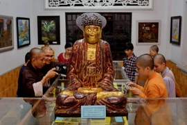 Đông đảo chư tôn đức tăng, ni cùng khách mời tham quan triển lãm. (Ảnh: Thế Anh/TTXVN)