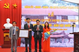 Cục phó cục Di sản trao quyết định công nhận pho tượng Trấn Vũ - Bảo vật quốc gia cho lãnh đạo phường Thạch Bàn - quận Long Biên. (Ảnh: Minh Đức/TTXVN)