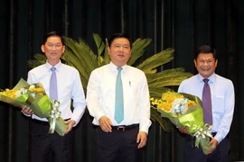 Bí thư Thành ủy Thành phố Hồ Chí Minh Đinh La Thăng chúc mừng 2 tân Phó Chủ tịch UBND Trần Vĩnh Tuyến và Huỳnh Cách Mạng. (Ảnh: Thanh Vũ/TTXVN)