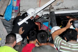 Nhân viên cứu hộ giải cứu nạn nhân bị mắc kẹt trong tòa nhà đổ sập sau trận động đất ở Manta, tỉnh Manabi, Ecuador ngày 17/4. (Ảnh: AFP/TTXVN) 