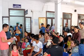 Hành lang Khoa khám nội và khám ngoại của Bệnh viện sản nhi Nghệ An luôn chật kín phụ huynh và trẻ nhỏ đợi để khám bệnh. (Ảnh: Tá Chuyên/TTXVN)