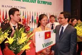 Phó Thủ tướng Vũ Đức Đam tặng hoa chúc mừng thành tích của thí sinh đoàn Việt Nam. (Ảnh: Quý Trung/TTXVN)