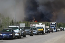 Đoàn xe sơ tán di chuyển tại khu vực đường cao tốc gần đám cháy rừng ở Fort McMurray, tỉnh Alberta, Canada ngày 6/5. (Ảnh: AFP/TTXVN) 