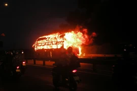 Xe khách bốc cháy trên Quốc lộ 1A. (Ảnh: Nguyễn Sơn/Vietnam+)