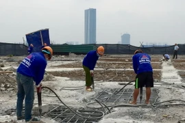 Công nhân Công ty Cổ phần Tập đoàn Phương Bắc dùng máy khoan phá dỡ phần trần bê tông. (Ảnh: Minh Nghĩa/TTXVN)