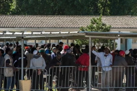 Người di cư chờ nhận khẩu phần ăn. (Ảnh: EPA/TTXVN)