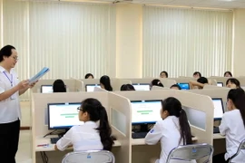 Giám thị phổ biến quy chế thi cho thí sinh trước giờ làm bài thi đánh giá năng lực môn Ngoại ngữ trên máy tính tại Đại học Quốc gia Hà Nội, sáng 5/5 vừa qua. (Ảnh: Quý Trung/TTXVN)