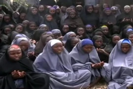 Các nữ sinh Nigeria bị Boko Haram bắt cóc trong trang phục Hồi giáo và đang làm lễ cầu nguyện tại một khu vực nông thôn không xác định được địa điểm ngày 12/5/2014. (Ảnh: AFP/TTXVN)