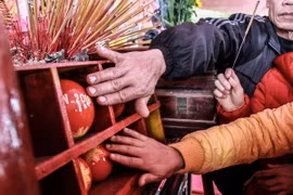 Sáu quả phết được làm từ gốc tre, sơn son thiếp vàng và ngự trên ban thờ. Nhiều người tranh thủ lúc thắp hương sờ vào quả phết với hy vọng gặp nhiều may mắn trong năm. (Ảnh: Quỳnh Trang/TTXVN)