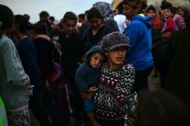 Người tị nạn và di cư xếp hàng đợi nhận khẩu phần ăn tại trại tị nạn ở Idomeni, biên giới Hy Lạp và Macedonia ngày 5/4. (Ảnh: AFP/TTXVN)