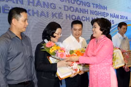 Phó Chủ tịch UBND TP.HCM Nguyễn Thị Hồng trao Bằng khen của Bộ Công Thương cho các đơn vị, doanh nghiệp có nhiều đóng góp tích cực trong chương trình kết nối Ngân hàng-doanh nghiệp năm 2014. (Ảnh: Thanh Vũ/TTXVN)