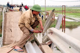 Tháo dỡ lan can cầu. (Ảnh: Công Tường/TTXVN)