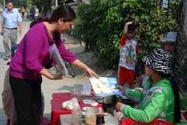 Cán bộ y tế phát tờ rơi tuyên truyền phòng, chống bệnh do virus Zika cho người dân. (Ảnh: Xuân Triệu/TTXVN)