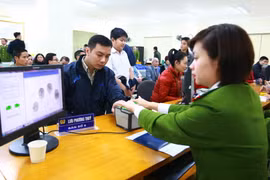 Cán bộ, chiến sỹ công an lấy làm thủ tục lấy dấu vân tay công dân đến đăng ký cấp thẻ căn cước công dân của Phòng Cảnh sát Quản lý hành chính về trật tự xã hội. (Ảnh: Doãn Tấn/TTXVN)