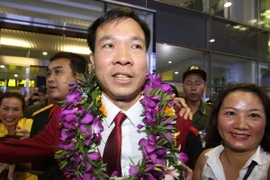 Xạ thủ Hoàng Xuân Vinh được đông đảo người hâm mộ chào đón tại sân bay quốc tế Nội Bài. (Ảnh: Quốc Khánh/TTXVN)