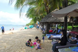 Du khách trên bãi biển thị trấn Dương Đông-Phú Quốc. (Ảnh: Thanh Vũ/TTXVN)