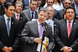 Tổng thống Colombia Juan Manuel Santos (giữa) công bố văn bản thỏa thuận hòa bình đạt được với lực lượng FARC ở Bogota ngày 25/8 vừa qua. (Ảnh: AFP/TTXVN)