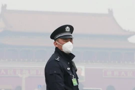 Cảnh sát Trung Quốc đeo khẩu trang tránh khói mù ô nhiễm tại thủ đô Bắc Kinh. (Ảnh: Reuters/TTXVN)