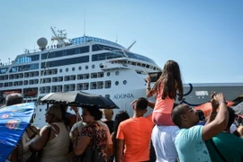 Người dân Cuba chào đón các hành khách trên du thuyền "The Adonia" tại cảng La Habana. (Ảnh: AFP/TTXVN)