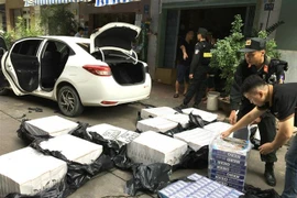 Lực lượng chức năng thu giữ tang vật vụ án. (Ảnh: TTXVN phát)