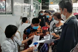 Kiểm tra sàng lọc sức khỏe trước khi tiêm vaccine COVID-19. (Ảnh: Tuấn Kiệt/TTXVN)