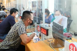 Người lao động làm thủ tục nhận bảo hiểm thất nghiệp Trung tâm Dịch vụ việc làm tỉnh Thanh Hóa. (Ảnh: Khiếu Tư/TTXVN)