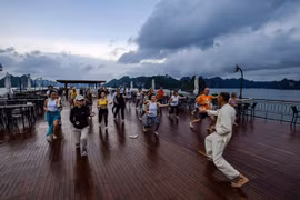 Du khách nghỉ dưỡng trên du thuyền tại vịnh Hạ Long kết hợp tập Taichi. (Ảnh: CTV/Vietnam+)