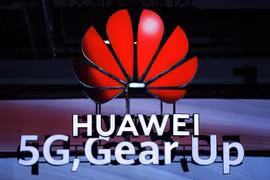 Biểu tượng Huawei và biểu tượng 5G. (Ảnh: AFP/TTXVN)