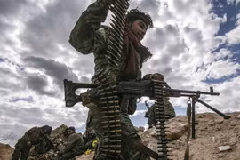 Một tay súng SDF được trang bị súng máy chuẩn bị tấn công vào làng Baghouz. (Nguồn: AFP)