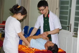 Các bác sỹ Bệnh viện Quân y 175 thăm khám cho bệnh nhân. (Ảnh: Đinh Hằng/TTXVN)