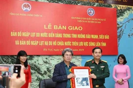 Bàn giao Bản đồ ngập lụt do nước biển dâng trong tình huống bão mạnh, siêu bão và Bản đồ ngập lụt hạ du hồ chứa nước trên lưu vực sông liên tỉnh. (Ảnh: Vũ Sinh/TTXVN)