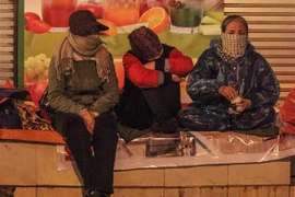 Người lao động co ro trong giá lạnh trên phố Tràng Thi, quận Hoàn Kiếm. (Ảnh: Minh Hoàng/TTXVN phát)