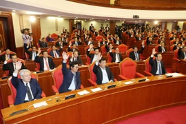 Đại biểu biểu quyết thông qua dự thảo Nghị quyết hội nghị lần thứ chín, Ban chấp hành Trung ương Đảng khóa XII. (Ảnh: Trí Dũng/TTXVN)