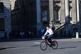 Người dân sử dụng xe đạp tại London, Anh. (Nguồn: AFP/TTXVN)