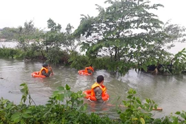Tìm kiếm thi thể nạn nhân Nguyễn Lữ Vân Anh, bị nước cuốn trôi tối 8/12. (Ảnh: Thanh Thủy/TTXVN)