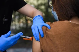 Nhân viên y tế tiêm vaccine phòng COVID-19 của hãng dược Pfizer-BioNTech cho người dân. (Ảnh: AFP/TTXVN)