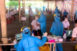 Lực lượng sinh viên Trường Đại học Y dược Cần Thơ hỗ trợ tỉnh Vĩnh Long xét nghiệm test nhanh cho công nhân Khu công nghiệp Hòa Phú. (Ảnh: Lê Thúy Hằng/TTXVN)