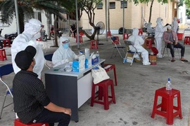 Cán bộ y tế test nhanh kháng nguyên SARS-CoV-2 cho lao động tại tỉnh Phú Yên. (Ảnh: TTXVN)