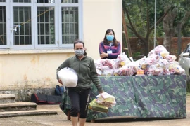 Người dân nhận nhu yếu phẩm từ Gian hàng 0 đồng. (Ảnh: Ngọc Minh/TTXVN)