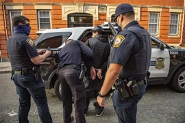 Cảnh sát Mỹ khám xét bắt giữ một nghi phạm. (Ảnh: AFP/TTXVN)