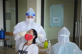 Nhân viên y tế lấy mẫu xét nghiệm COVID-19. (Ảnh: Danh Lam/TTXVN)