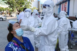 Nhân viên bán hàng thiết yếu siêu thị Co.op Mart Tuy Hòa, Phú Yên được lấy mẫu xét nghiệm SARS-CoV-2. (Ảnh: Phạm Cường/TTXVN)