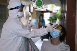Lực lượng y tế lấy mẫu xét nghiệm SARS-CoV-2 cho những người có nguy cơ cao. (Ảnh: Hoàng Hiếu/TTXVN)