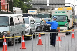 Lực lượng chức năng tại chốt cao tốc Hà Nội-Lạng Sơn (chân cầu Phù Đổng) yêu cầu các tài xế xuống xe để kiểm tra và khai báo y tế. (Ảnh: Thành Đạt/TTXVN)