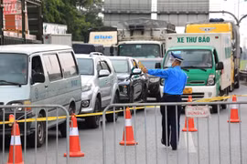 Lực lượng chức năng tại chốt cao tốc Hà Nội-Lạng Sơn (chân cầu Phù Đổng) yêu cầu các tài xế xuống xe để kiểm tra và khai báo y tế. (Ảnh: Thành Đạt/TTXVN)